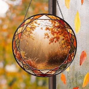 May include: A round stained glass window with a fall scene. The window features a forest path with trees in shades of orange and yellow. The border is a geometric pattern of orange, red, and green.