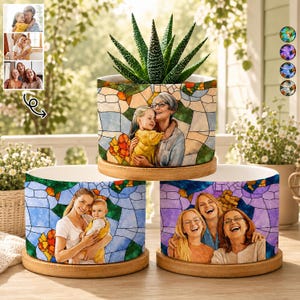 May include: Three ceramic flower pots with family portraits in a stained glass style. Each pot has a wooden base and a succulent plant. The portraits depict a grandmother with a granddaughter, a mother with a baby, and a group of three women.
