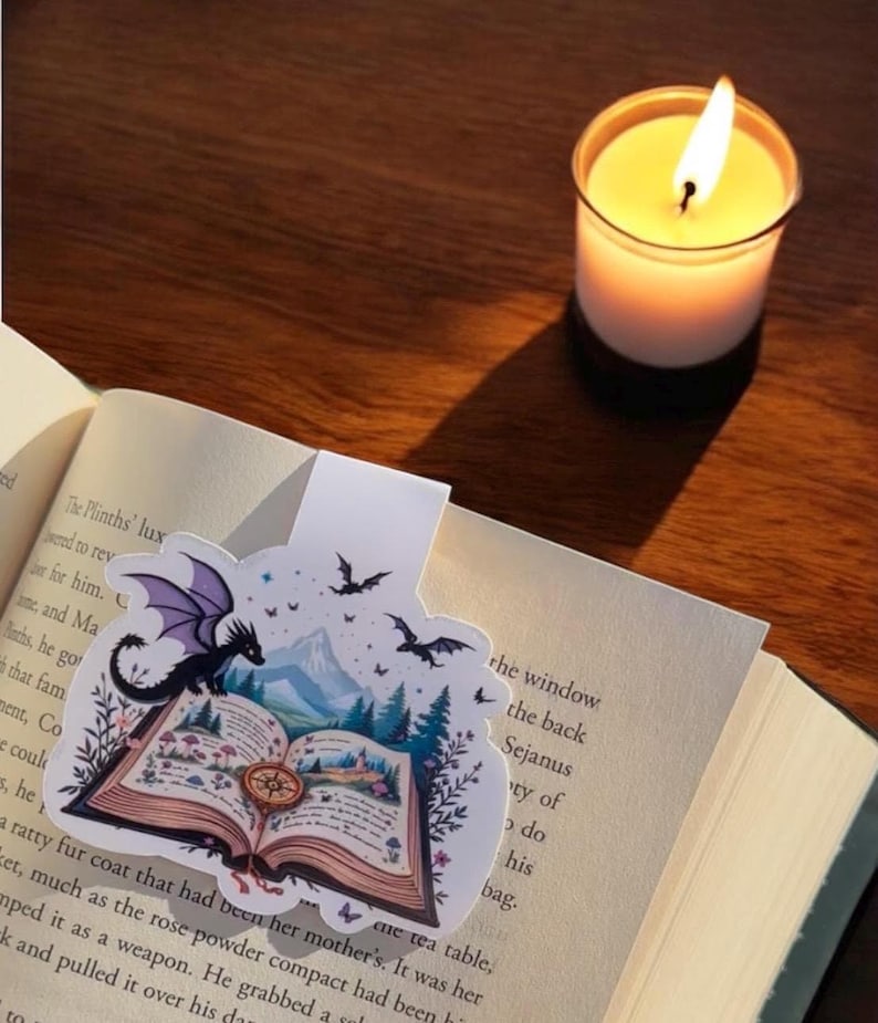 May include: A purple and black dragon bookmark with a book, mountains, and bats in the background. The bookmark is on a book with the text "The Plinths' lux" visible.