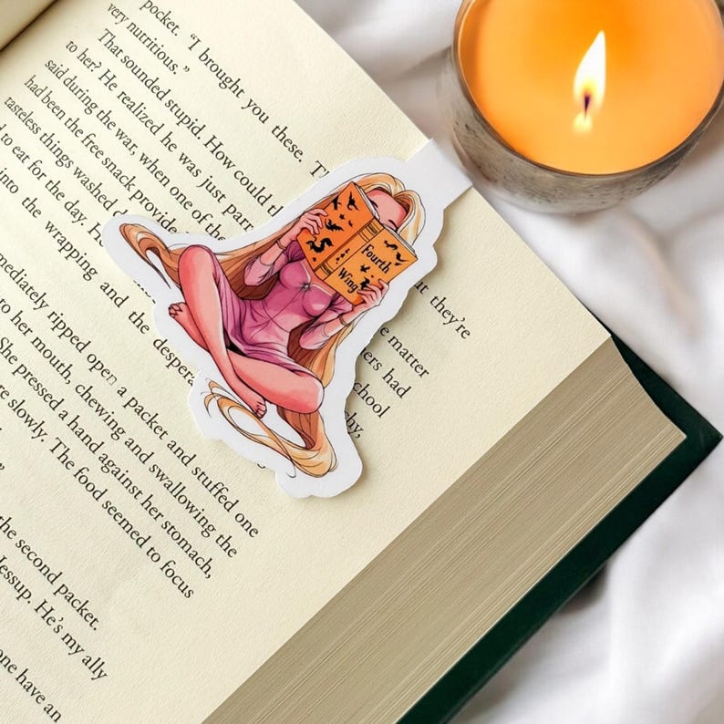 Op de afbeelding: Een bladwijzer met een cartoonillustratie van een vrouw met lang blond haar die een boek leest met de titel "Fourth Wing". De bladwijzer bevindt zich op een boek met een groene kaft.