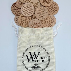 May include: A beige drawstring fabric pouch printed with the text Word Wafers and Matthew 4:4, filled with multiple round wooden tokens engraved with various religious phrases and scripture verses in dark brown lettering.