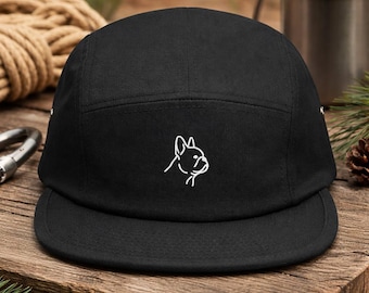 May include: Black five-panel cap with a flat peak. The cap has a white outline of a French Bulldog's head on the front. The hat is made of a sturdy fabric and is suitable for outdoor wear. A stylish accessory for dog lovers.