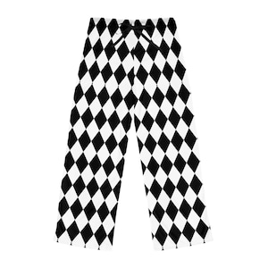 May include: Black and white diamond-patterned pajama pants. The pants have a drawstring at the waist. The harlequin-style design features repeating black diamonds on a white background. The pajama pants are made of a soft, comfortable material.