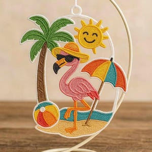 May include: Embroidered beach scene with a pink flamingo wearing sunglasses and a hat. Includes a palm tree, sun, beach ball, and a colorful umbrella. The design is set within a white, circular frame, perfect for summer decor.