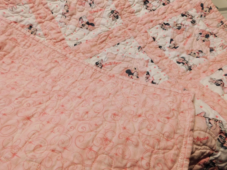 Puede incluir: Edred&oacute;n rosa y blanco con un dise&ntilde;o de Minnie Mouse. El edred&oacute;n presenta un patr&oacute;n repetitivo de Minnie Mouse sobre un fondo blanco con lunares rosas. El edred&oacute;n est&aacute; hecho de tela suave y est&aacute; acolchado a m&aacute;quina.