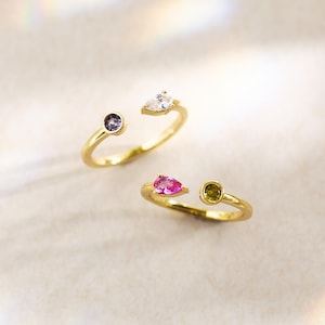 May include: A white ceramic mug with a black handle and the text "But First, Coffee" in a black, bold font. The mug is on a white surface. The mug is likely for hot beverages.