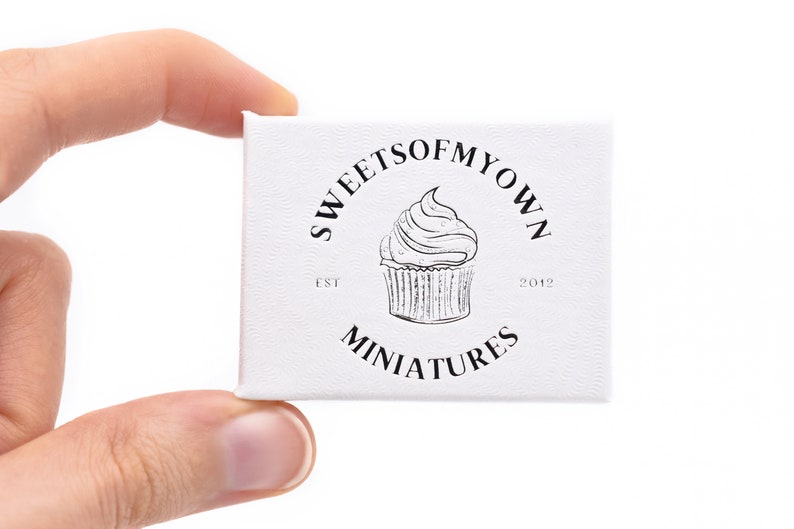Peut inclure: Bo&icirc;te blanche avec un logo noir et blanc qui dit "Sweets of My Own Est. 2012 Miniatures". Le logo repr&eacute;sente un cupcake avec du gla&ccedil;age.
