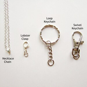 May include: A silver necklace chain with a lobster clasp, a loop keychain with a silver chain, and a swivel keychain.