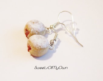 May include: A pair of silver dangle earrings featuring miniature jelly-filled donuts with powdered sugar. The donuts are a light brown color with a red jelly filling visible.