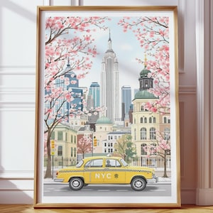 May include: A framed art print depicts a New York City scene. A yellow taxi cab with "NYC" on the side is on a street with buildings and cherry blossom trees. The Empire State Building is in the background.
