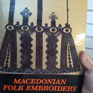 May include: A book cover with a brown and black geometric design and the text "Macedonian Folk Embroidery".