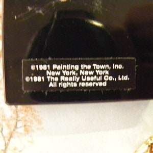 May include: Close-up of a black label with white text. The text reads: &copy;1981 Painting the Town, Inc. New York, New York &copy;1981 The Really Useful Co., Ltd. All rights reserved.