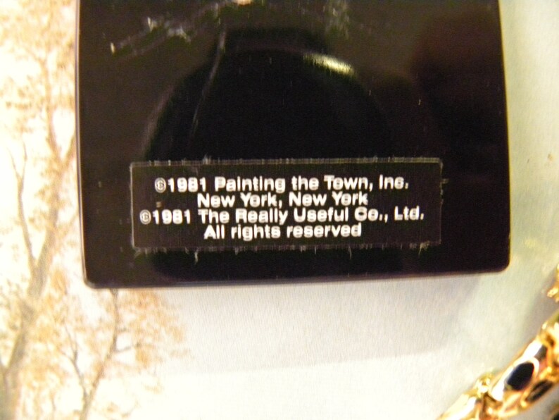 May include: Close-up of a black label with white text. The text reads: &copy;1981 Painting the Town, Inc. New York, New York &copy;1981 The Really Useful Co., Ltd. All rights reserved.