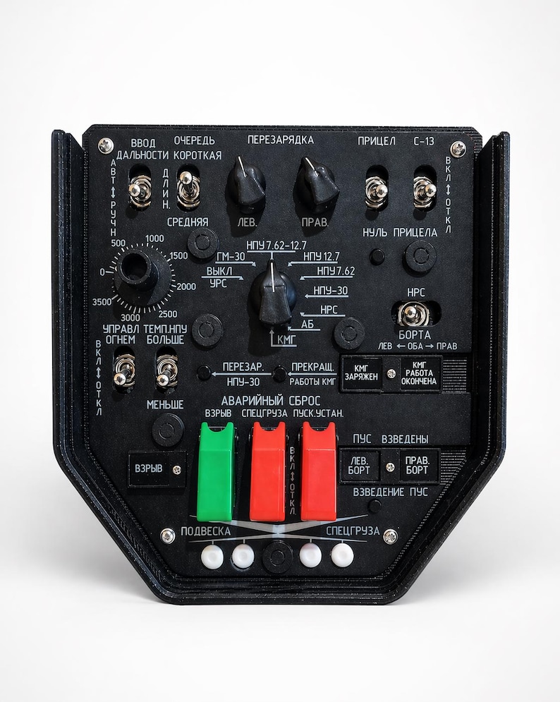 May include: A black control panel with numerous buttons, switches, and dials. The panel has text in a foreign language, with red and green toggle switches. The panel has a hexagonal shape.