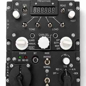 Puede incluir: Panel de control electrónico negro con múltiples interruptores, diales y una pantalla digital. El panel tiene etiquetas como "VOL", "FREQ", "CHAN" y "MODE".