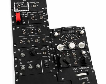 Op de afbeelding: Zwart vliegtuigbedieningspaneel met diverse schakelaars, knoppen en labels. Bevat "INLET RAMP", "THROTTLE", "AIRSTART" en "OXYGEN". Het paneel heeft een rode schakelaar en digitale displays. Ontworpen voor luchtvaart.