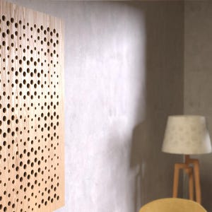 Puede incluir: Un panel acústico de madera con un patrón circular de agujeros. El panel está montado en una pared de color beige claro.