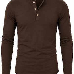 Puede incluir: Una camiseta tipo henley de manga larga en color marrón oscuro sólido. La prenda presenta un cuello redondo con una tapeta de botones parcial que incluye tres botones de color claro. La tela tiene una textura lisa y mangas largas.