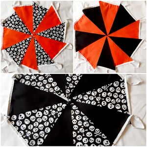 May include: Halloween-themed bunting flags in three arrangements. The flags feature orange, black, and skull-patterned fabric. Each flag is triangular, with white trim and ties for hanging. The bunting is suitable for festive decorations.