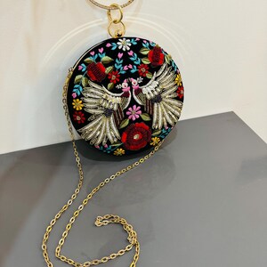 Cartera de mano redonda bordada a mano con diseño de pájaros y flores y asa con anilla dorada