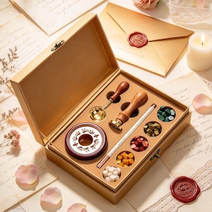 May include: A gold-colored gift box containing a wax seal kit. The set includes a wooden-handled brass stamp, a metal melting spoon, a dark red wax warmer, a white candle, and five small containers filled with wax beads in green, gold, red, yellow, and white.