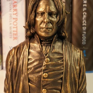 Peut inclure: Buste en bronze de Severus Rogue, un personnage de la série Harry Potter. Le buste est détaillé et montre les cheveux noirs et longs et les vêtements sombres caractéristiques de Rogue.
