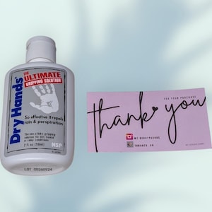 May include: A white bottle of "Dry Hands" gripping solution with a white cap, and a pink card that says "thank you". The bottle has a label with the text "The Ultimate Gripping Solution" and a handprint graphic. The card has the seller's Instagram handle.