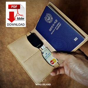 May include: A tan leather passport holder with a blue passport inside. The passport has the text "대한민국 여권" and "REPUBLIC OF KOREA PASSPORT" printed on the cover. The holder has two card slots and a pocket for cash or other documents.