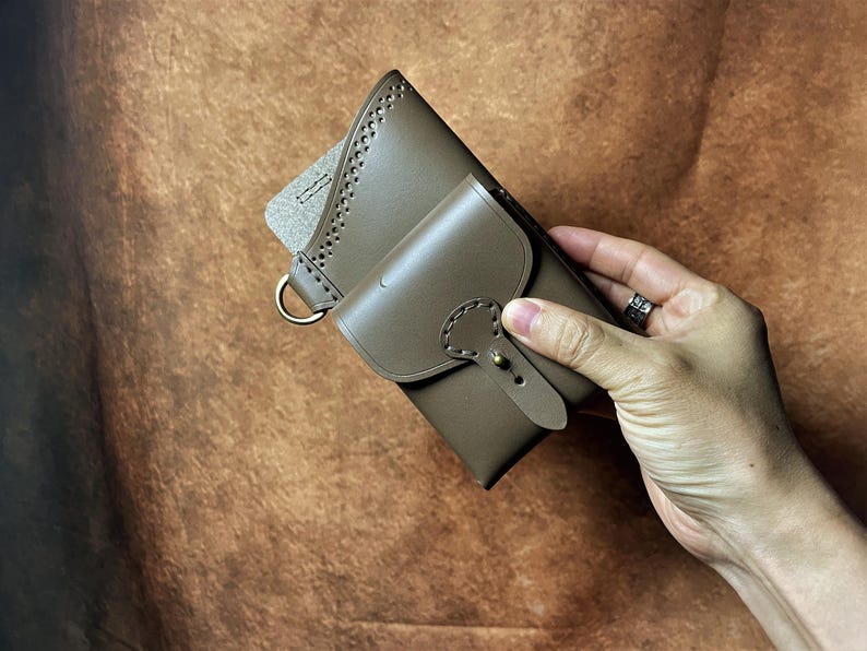 May include: A white ceramic mug with a black handle and the text "But First, Coffee" in a bold, black font. The mug is on a wooden surface. The mug is approximately 10 cm tall.