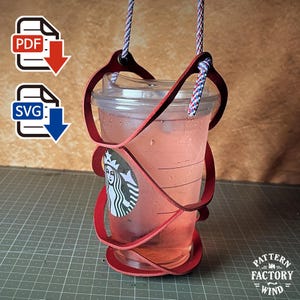 Puede incluir: Un portavasos de cuero rojo con un diseño en espiral que envuelve un vaso de plástico transparente de Starbucks. El portavasos incluye un asa de cuerda trenzada azul, blanca y roja sujeta con remaches metálicos. Incluye iconos de descarga PDF y SVG.