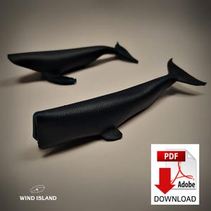 Może przedstawiać: Dwie czarne figurki wielorybów, jedna większa od drugiej, z fakturowaną powierzchnią. Większy wieloryb leży na boku, podczas gdy mniejszy pływa. Obraz zawiera również przycisk pobierania pliku PDF.