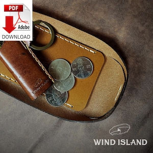 Könnte beinhalten: Eine braune Lederbörse mit einem Schlüsselring und einem kleinen Fach für Münzen. Die Börse hat einen genähten Rand und der Text "WIND ISLAND" ist auf der Vorderseite geprägt.