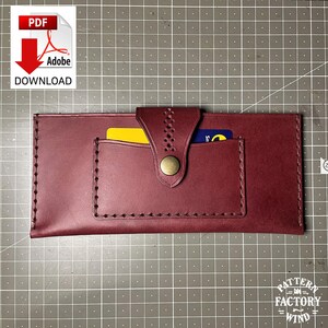 May include: A burgundy leather wallet with a snap closure and stitched detailing. The wallet has a card slot and holds a yellow and a blue credit card. The wallet is rectangular and has a PDF download icon in the upper left corner.