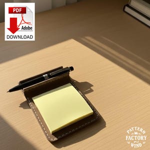 May include: A brown leather notepad holder with a yellow sticky note pad and a black pen. The notepad holder has white stitching around the edges. The image also includes a PDF download icon.
