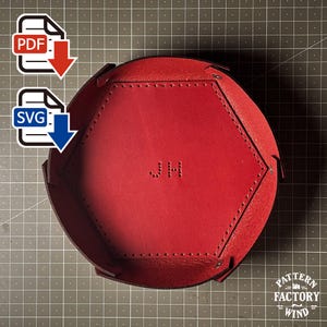 Könnte beinhalten: Ein rotes sechseckiges Leder Tablett mit genähten Kanten und den Initialen "JH" in der Mitte geprägt. Das Tablett ist für die Aufbewahrung kleiner Gegenstände konzipiert. PDF- und SVG-Download-Symbole in der oberen linken Ecke.