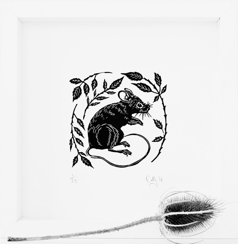 May include: Black and white linocut print of a mouse sitting in a circle of leaves. The print is signed "Calle 16" in the bottom right corner.
