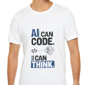 May include: A white short-sleeved t-shirt featuring a graphic print with the text AI CAN CODE. I CAN THINK. in blue and black lettering, accompanied by a code bracket symbol and a stylized brain icon with digital particles on the front center.