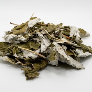 May include: A pile of dried, light brown and white leaves. The leaves are slightly curled and have a rough texture.