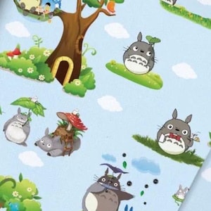 Könnte beinhalten: Hellblauer Stoff mit einem sich wiederholenden Muster aus grauen Totoro-Figuren, grünen Bäumen, roten Pilzen und weißen Wolken. Die Illustrationen zeigen verschiedene Szenen, in denen die Figuren Regenschirme halten, auf Gras sitzen und mit der Natur interagieren.