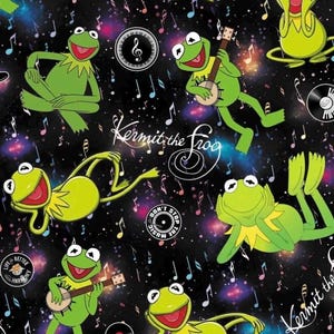 Könnte beinhalten: Ein schwarzer Stoff mit einem sich wiederholenden Muster von Kermit dem Frosch in verschiedenen Posen, unter anderem beim Banjo spielen. Das Design enthält bunte Musiknoten, Schallplatten sowie den Text "Kermit the Frog" und "Don't Stop the Music" vor einem kosmischen, sternenreichen Hintergrund.