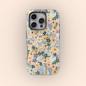 Könnte beinhalten: Eine Handyhülle mit floralem Muster. Sie zeigt ein Muster aus kleinen Blumen in Blau-, Rosa-, Gelb- und Grüntönen auf cremefarbenem Hintergrund. Mit schwarzem Rand und Kameraausschnitt.