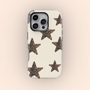 May include: A phone case with a cream-colored background and a pattern of leopard print stars. The case has a black camera module and black side buttons. The stars vary in size and are evenly spaced across the surface.