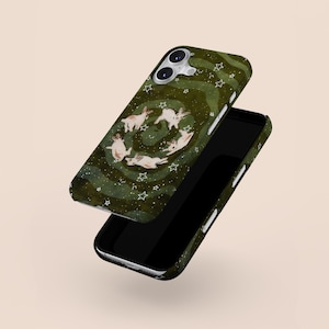 Puede incluir: Una funda de tel&eacute;fono verde con un dise&ntilde;o caprichoso de conejos blancos en c&iacute;rculo, rodeados de estrellas blancas. La funda tiene un patr&oacute;n verde ondulado y se muestra con un tel&eacute;fono negro.