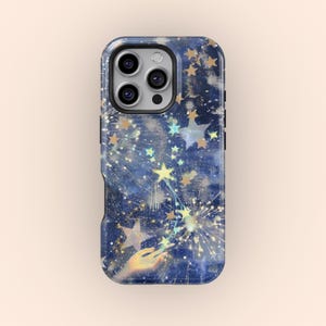 Puede incluir: Funda de teléfono con un diseño celestial. La funda presenta un fondo azul oscuro con estrellas doradas y amarillas, una mano que se extiende hacia arriba y un patrón de constelación. La funda tiene un acabado brillante y un borde negro.