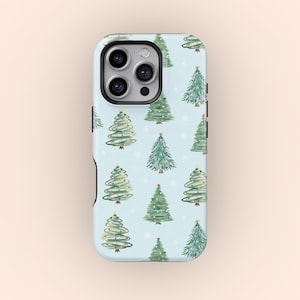 May include: A light blue phone case featuring a repeating pattern of green Christmas trees with yellow star toppers. The trees are set against a background of white snowflakes. The case has a black camera module.