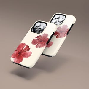 May include: Two off-white phone cases with a red hibiscus flower design. The cases have a glossy finish and a black border. The hibiscus flowers are in full bloom, with detailed petals and a vibrant red color.
