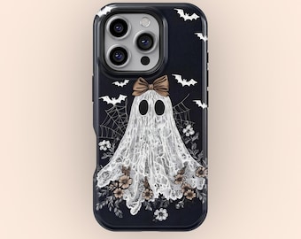Puede incluir: Funda de teléfono negra con un diseño de fantasma blanco, un lazo marrón y detalles florales. El fondo oscuro presenta murciélagos blancos y telarañas. Un accesorio espeluznante para Halloween.