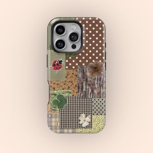 Könnte beinhalten: Handyhülle im Patchwork-Design mit verschiedenen Mustern, darunter Punkte, Blumenmuster und Vichy-Karo. Verziert mit einem Marienkäfer, einem vierblättrigen Kleeblatt und einer Blume. Die Hülle hat einen grünen Rand und einen Kameraausschnitt.