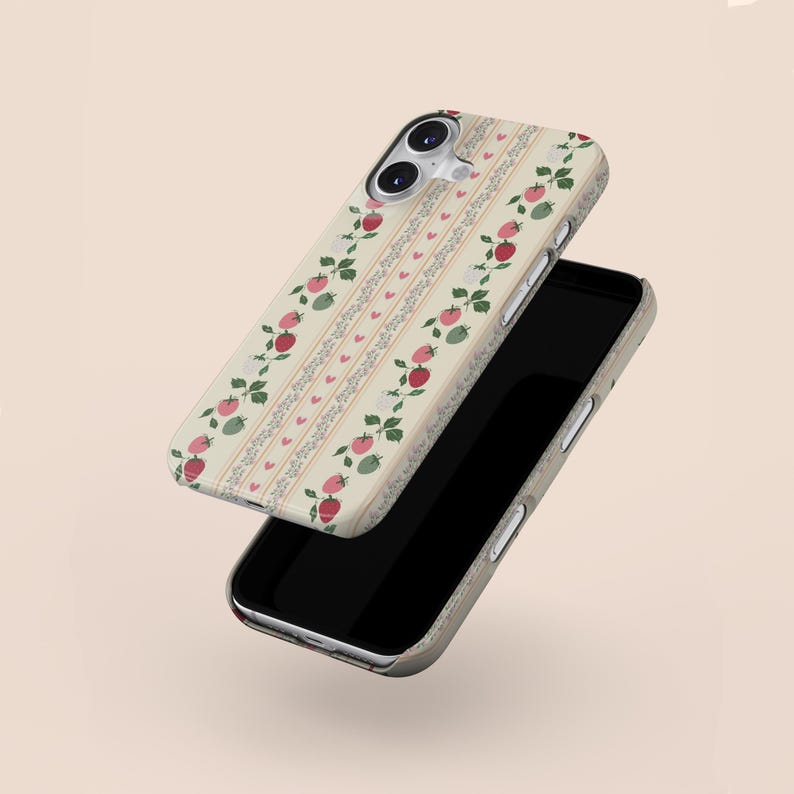 Peut inclure: Une coque de t&eacute;l&eacute;phone iPhone blanche avec un motif de fraises rouges et vertes et de petits c&oelig;urs. La coque est pr&eacute;sent&eacute;e avec le t&eacute;l&eacute;phone sur un &eacute;cran noir.