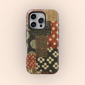 Può includere: Custodia per telefono con motivo patchwork. Presenta un mix di motivi marroni, neri e rossi, tra cui disegni floreali, geometrici e a pois. La custodia è progettata per adattarsi a uno smartphone, offrendo un aspetto unico e strutturato.